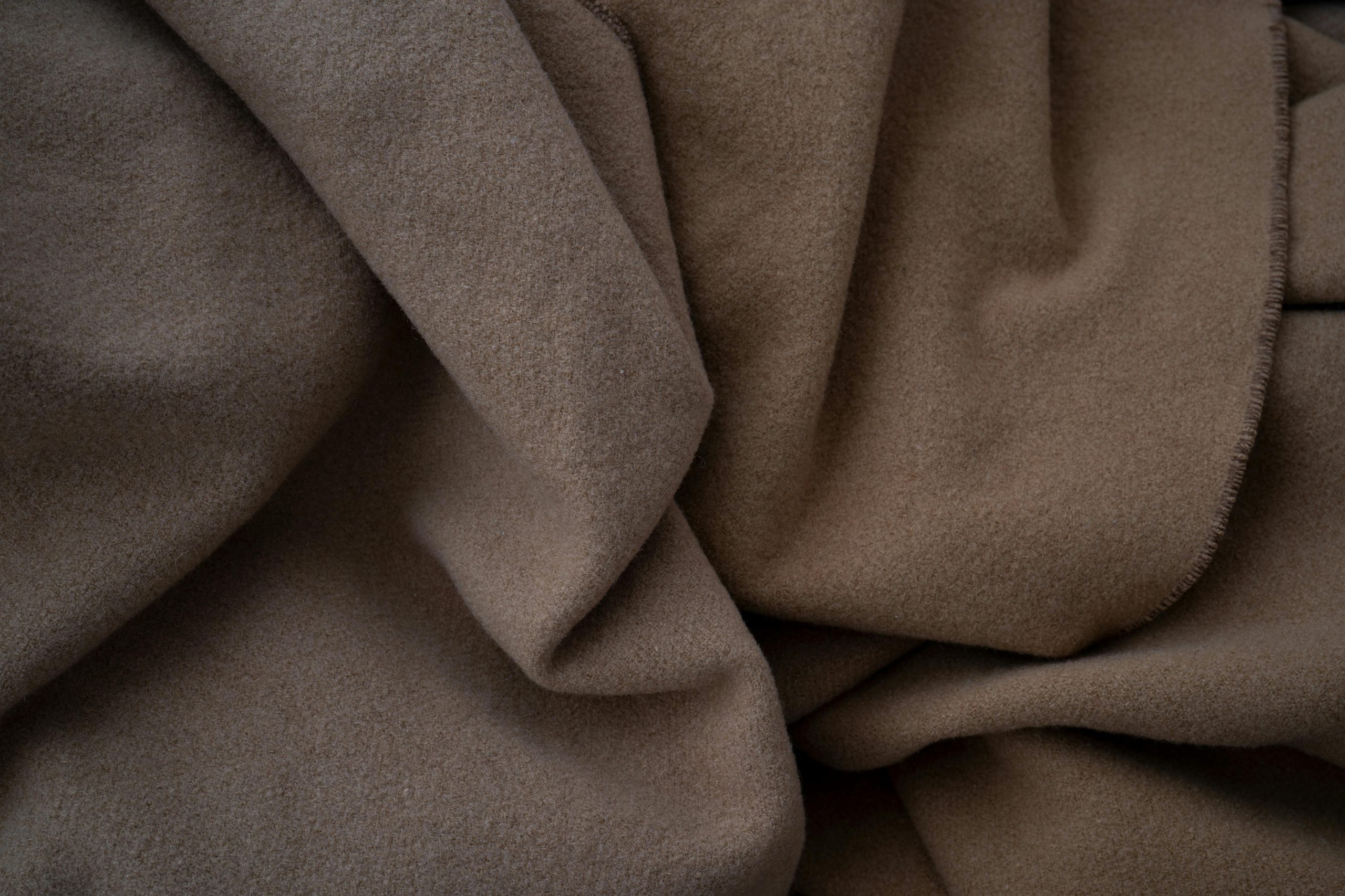 A close-up view of soft brown fabric texture. Ideal for backgrounds or textile design projects.